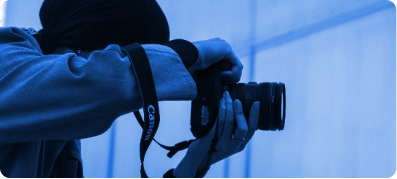 A man holding a camera showcasing his photography skills.